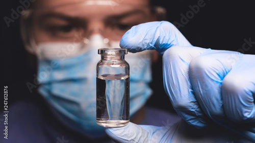Laboratory worker scientist laboratory assistant tests chemicals for reactions in test tubes, interfering with different substances and obtaining a visual reaction. Concept of: Science, Chemistry.