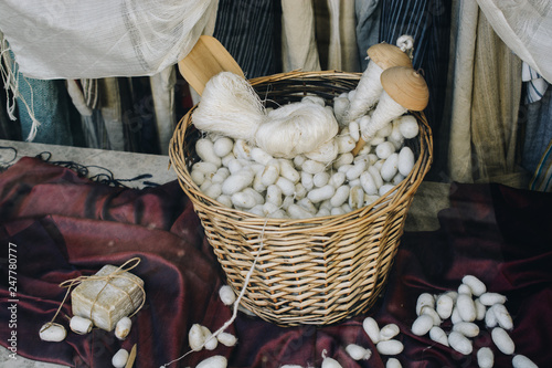 Lots of white silkworm cocoons in straw basket