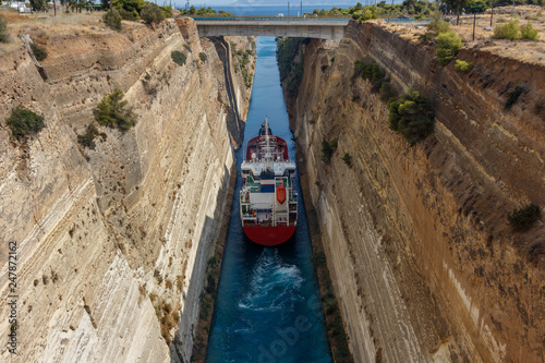 Large ship passing through Corinth canal. The Corinth Canal connects the Gulf of Corinth with the Saronic Gulf in the Aegean Sea. It separates Peloponnese from the Greek mainland.