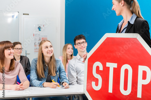 Driving instructor holding theoretical part of driving lessons