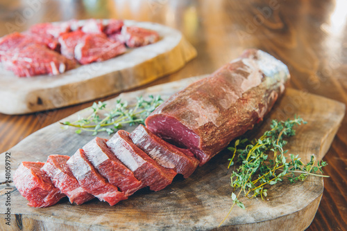 Raw and fresh beef steak rib eye sliced sirloin meat on wooden table in restaurant.