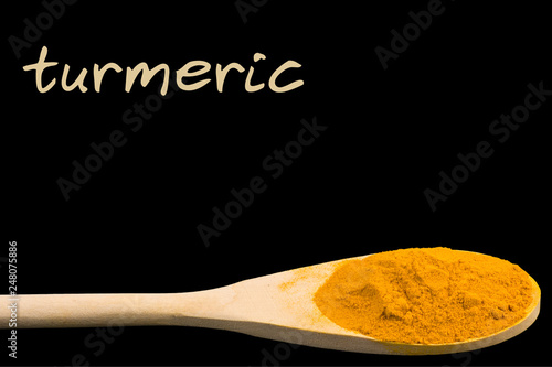 turmeric on wooden spoon isolated on black background
