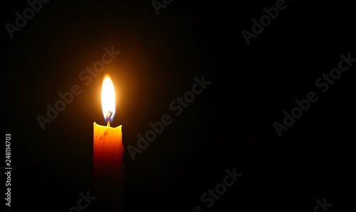 Yellow candle light burn against black background