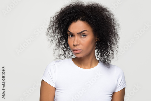Suspicious african woman with distrustful face looking at camera