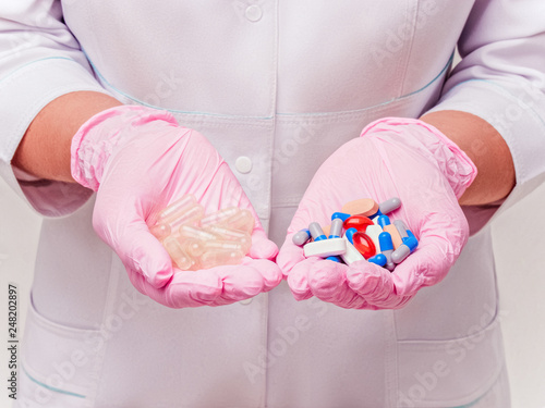 Placebo drugs concept. Doctor holds pills and placebo's. Hand in pink Gloves with Pills. Empty pills. Healthcare concept