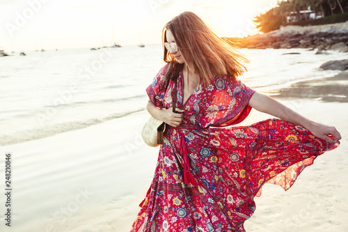 Beautiful girl in boho maxi dress on the beach