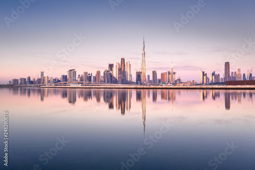 Beautiful colorful sunrise lighting up the skyline and the reflection of Dubai Downtown. Dubai, United Arab Emirates.