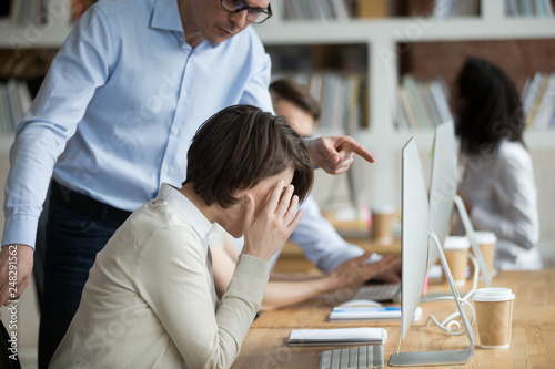 Stressed female employee suffering from discrimination of angry male boss