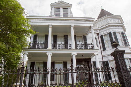 Women's Opera Guild House in Garden District of New Orleans, Louisiana, USA. White antebellum mansion with black rod iron fence. Daytime, horizontal