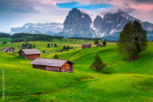 Seiser Alm resort and wooden chalets at sunset, Dolomites, Italy