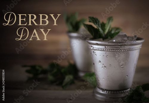 Image for Kentucky Derby in May showing two silver mint julep cups with crushed ice and fresh mint in a rustic setting