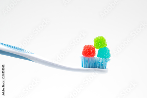 toothbrush with sweets, concept of health and dental care and unhealthy sugar abuse