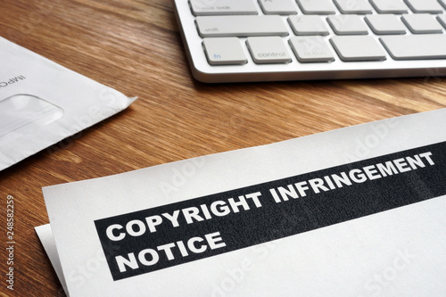 Letter with copyright infringement notice on a desk.