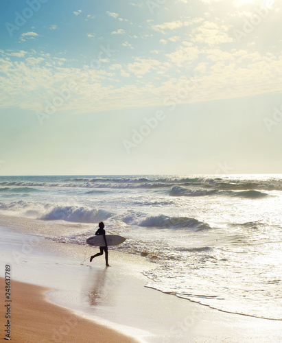 Surfer running to surf