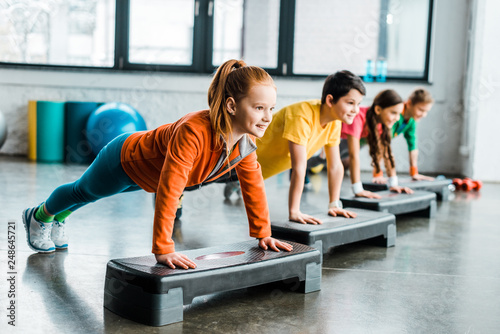 Children doing plank exercise with step platforms