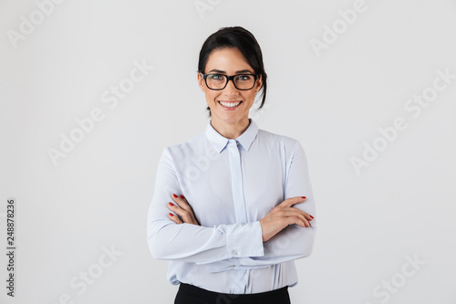 Photo of pretty businesslike woman wearing eyeglasses standing in the office, isolated over white background