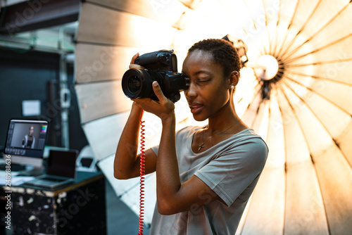 Young photographer standing in front of a reflective umbrella