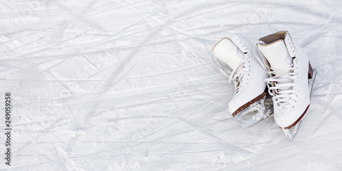 close up of figure skates and copy space over ice background with marks from skating or hockey