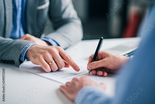 Businessmen hand's pointing where to sign a contract, legal papers or application form.