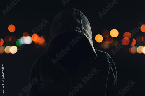 Hooligan with hoodie and obscured face at night