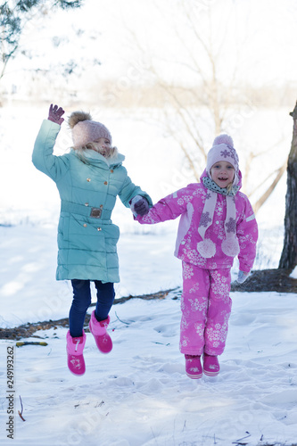 baby girls playing in snowy winter forest