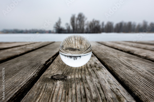 Glass sphere on a public bathing place in winter, frozen water