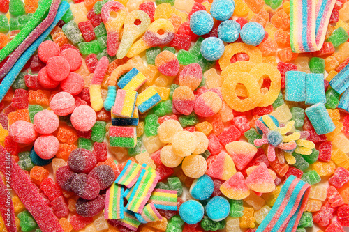 Assorted variety of sour candies includes extreme sour soft fruit chews, keys, tart candy belts and straws.