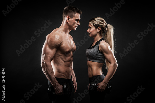 Sporty young couple posing on black background