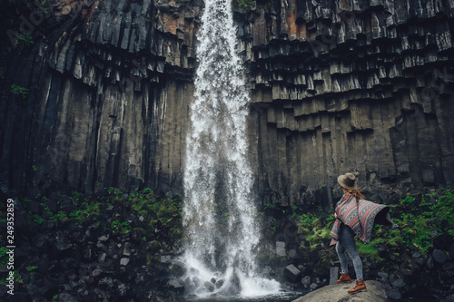 Beautiful landscape of Iceland. Girl looking on waterfall