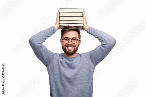 Cheerful student holding books on head