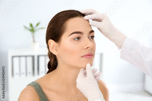 Dermatologist examining patient's face in clinic. Skin cancer checkup