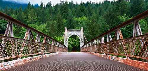 Rusty metal suspension bridge over the Fraser river near Lillooet, British Columbia, Canada