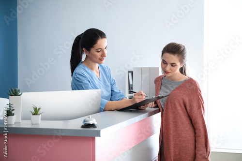 Young woman near reception desk in clinic