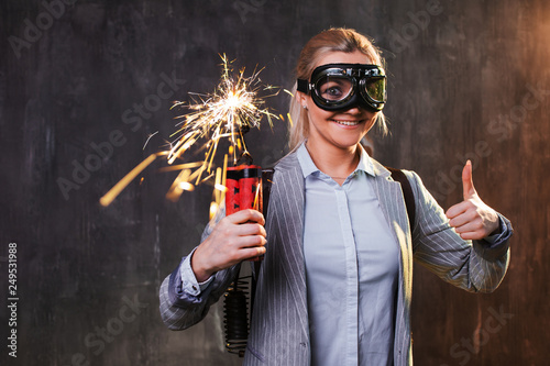 Energetic young female leader with explosives and jetpack behind