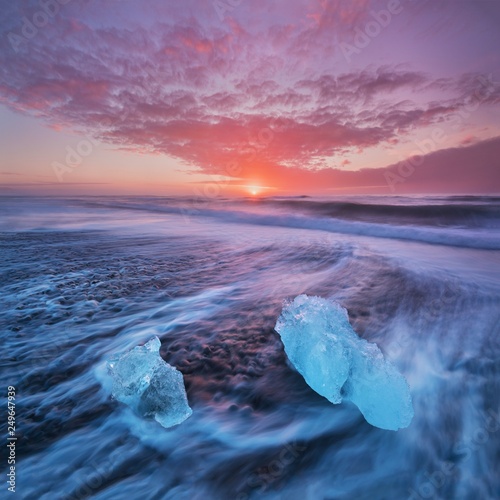 Beautiful sunset over famous Diamond beach, Iceland. This sand lava beach is full of many giant ice gems, placed near glacier lagoon Jokulsarlon Ice rock with black sand beach in southeast Iceland