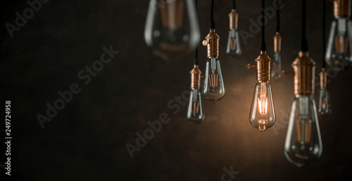 Individuality concept, one bright light bulb standing out from the crowd with copy space