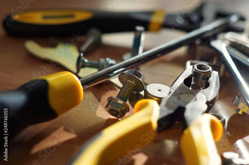 Do It Yourself DIY accessories - locksmith tools, wrenches, screwdrivers, pliers, nuts and bolts on a wooden table