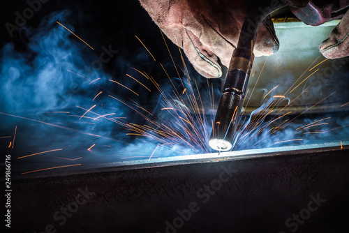 Industrial welder welding fabricated construction in factory, Welding process by Flux Core Welding, FCAW