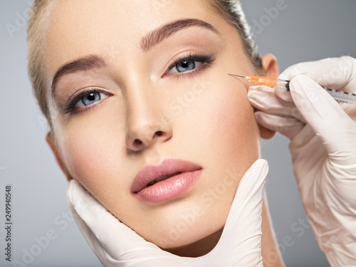 Woman getting cosmetic injection of botox in cheek