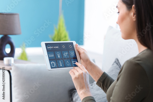 Young woman using application of smart home automation