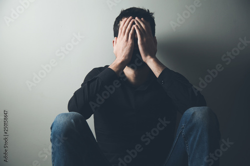 sad man sitting hand in face