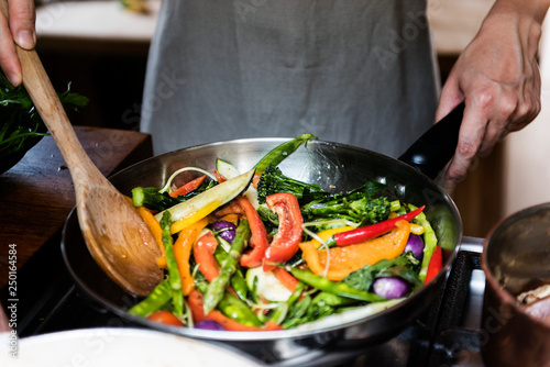 Japanese woman cooking stir fried vegetables