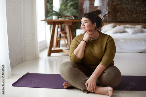 Young woman sitting on yoga mat