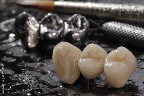 Macro E-max pressed ceramic bridge and metal crown with dentistry utensils