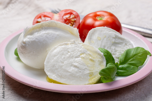 Soft white Italian cheese Mozzarella buffalo served with fresh tomato and green basil leaves
