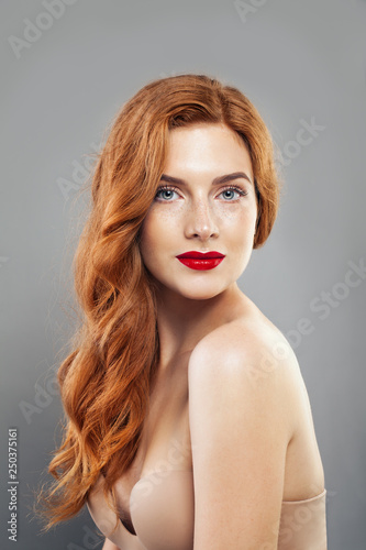 Tender redhead girl with healthy freckled skin. Caucasian woman model with ginger hair posing indoors