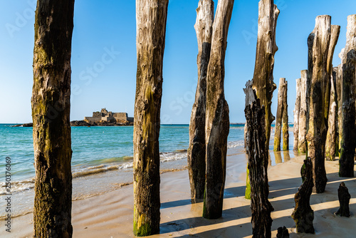 Wooden Poles outside Saint Malo walls at low tide