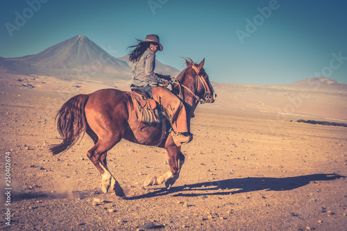 cowgirl woman riding a horse in the desert