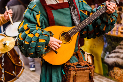 Średniowieczny trubadur grający na gitarze antycznej.