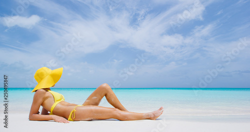 Luxury beach travel - Sexy woman sunbathing on the beach with bikini beach body. Beautiful multiracial Asian Caucasian female model on travel vacation holidays.